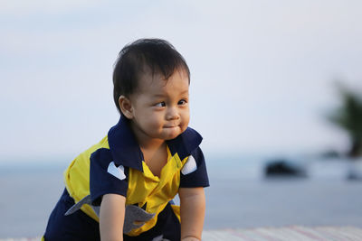 Portrait of cute boy against sea against sky