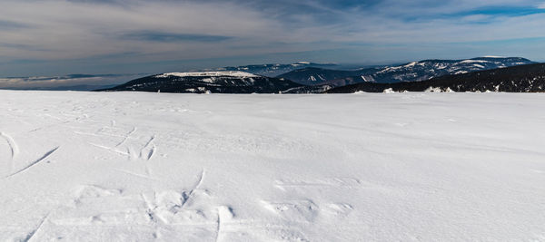 Snow covered landscape against sky