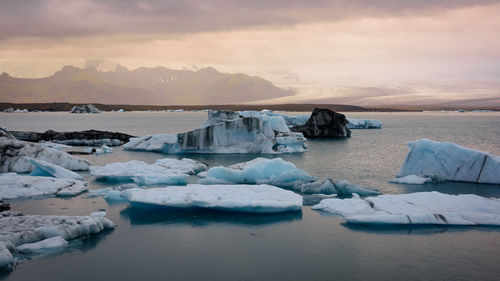 Scenic view of frozen sea against sky during sunset