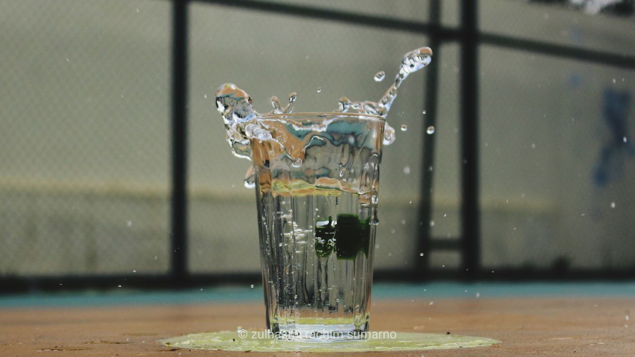 CLOSE-UP OF WATER SPLASHING IN GLASS