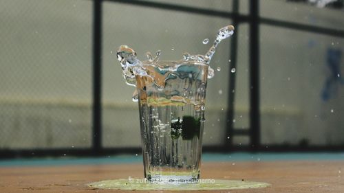 Close-up of water splashing on glass table