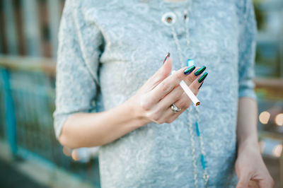 Midsection of woman holding cigarette