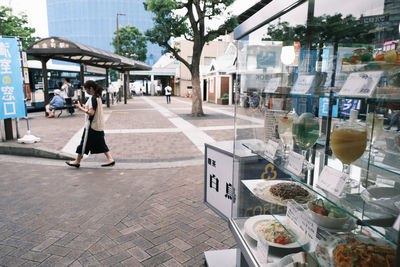 People walking on footpath in city