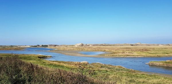 Scenic view of land against clear blue sky