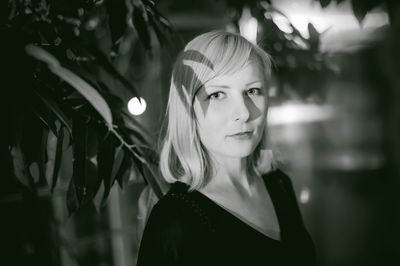 Close-up portrait of young woman by twigs