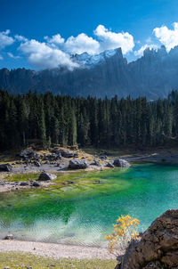 Scenic view of lake carezze  and mountains against sky in italy