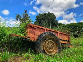 Old abandoned truck on field against sky