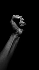 Close-up of human hand against black background