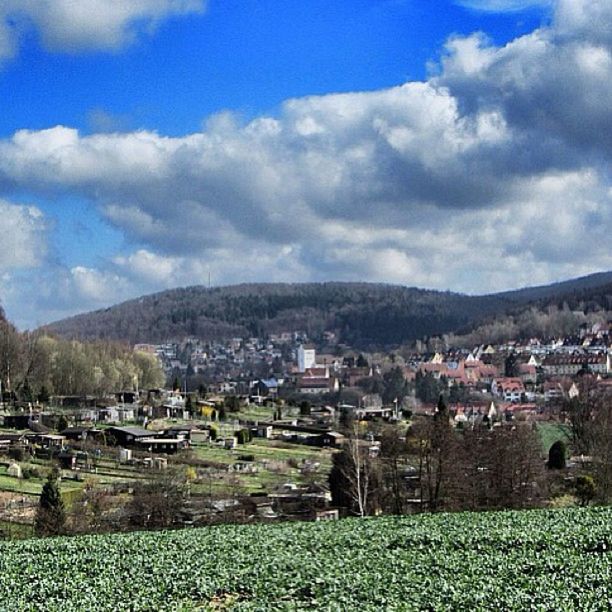 sky, building exterior, architecture, built structure, cloud - sky, mountain, house, cloud, cloudy, landscape, residential structure, residential building, mountain range, residential district, town, tree, nature, scenics, townscape, tranquil scene