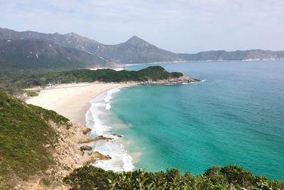 Scenic view of sea and mountains against sky