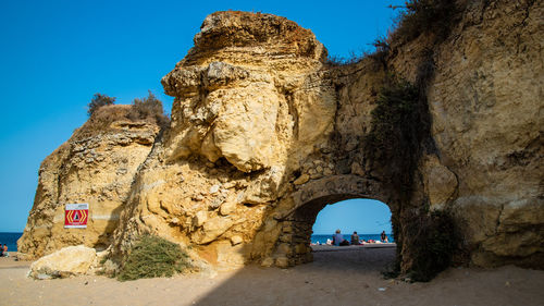 Archway of rock formation against clear sky
