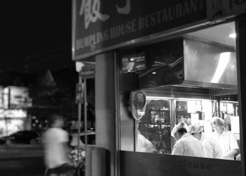 Rear view of people walking on street in city at night