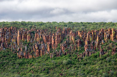 View of rocks on landscape against cloudy sky