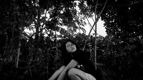 Young woman sitting amidst plant