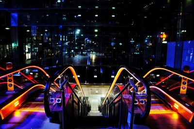 Multi colored illuminated bridge in city at night