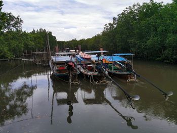 Boats moored in lake against sky