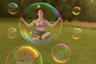 Digital composite image of woman doing yoga in bubble