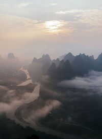 Mountain peaks under cloudy sky at sunrise, guilin, china