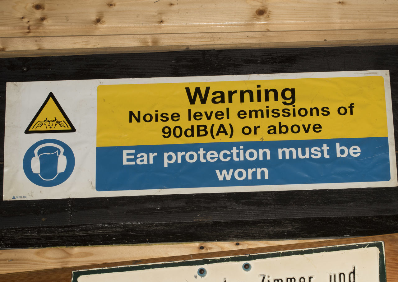 HIGH ANGLE VIEW OF WARNING SIGN ON WOODEN WALL