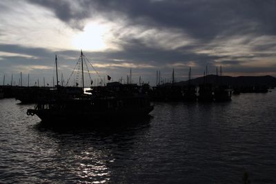 Boats in sea at sunset