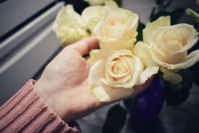 Close-up of hand holding rose bouquet