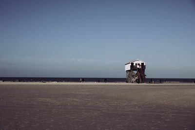 Lifeguard hut at beach against clear sky