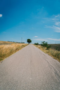 Road amidst landscape against clear blue sky