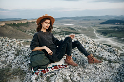 Young woman sitting on rock