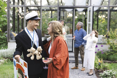 Happy mother and son looking at each other while standing at back yard during summer party