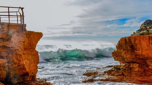 Rock formations by sea against sky and the colors of light through the wave