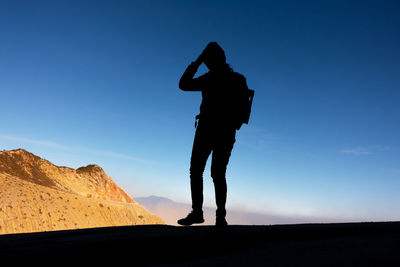 Silhouette woman standing against blue sky