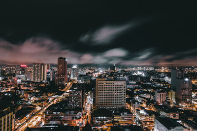 Illuminated cityscape against sky at night