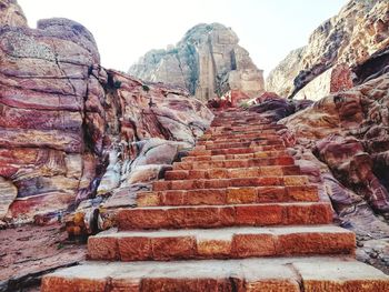 Low angle view of steps and mountain against sky