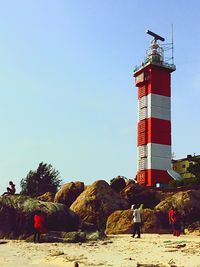 Traditional windmill on beach against clear sky