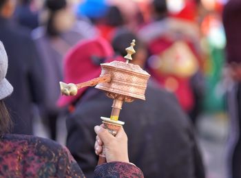 Rear view of woman spinning prayer wheel outdoors