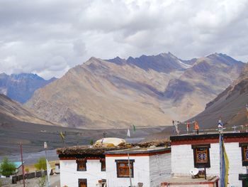 Buddhist monasteries by himalayas against cloudy sky