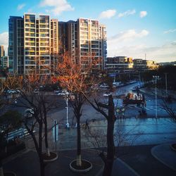 Buildings by river against sky in city