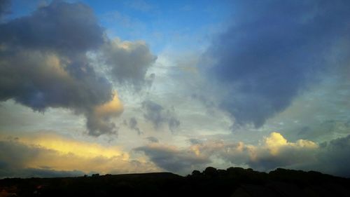 Low angle view of silhouette trees against sky