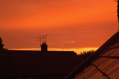 Low angle view of silhouette roof against sky during sunset