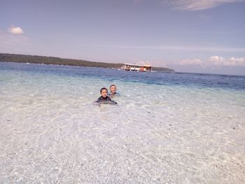 People enjoying in sea against sky