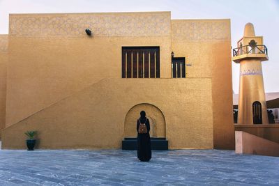 Portrait of woman sitting outside building