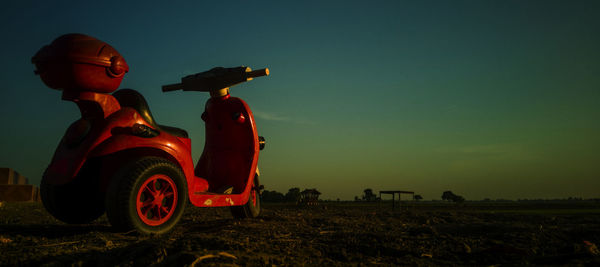 Man with toys on field against sky at sunset