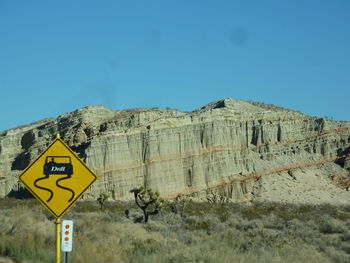 Road sign against clear blue sky