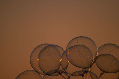 Glowing baloons in front of sunset sky
