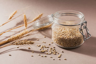Glass jar of dry raw broken pearl barley cereal grain