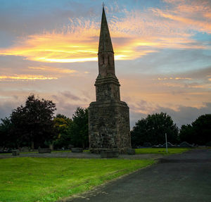 View of temple on field against cloudy sky