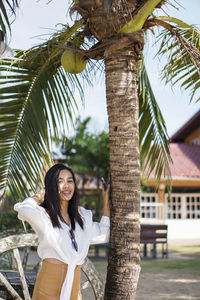 Woman with coconut tree on the beach