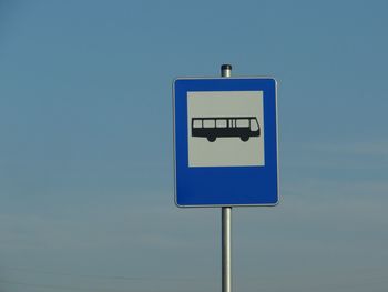 Low angle view of information sign against clear blue sky