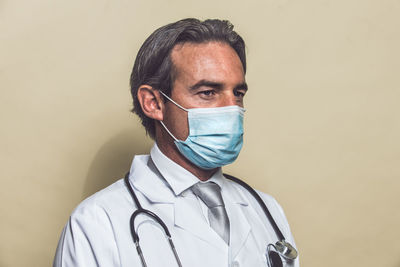 Doctor wearing mask against colored background