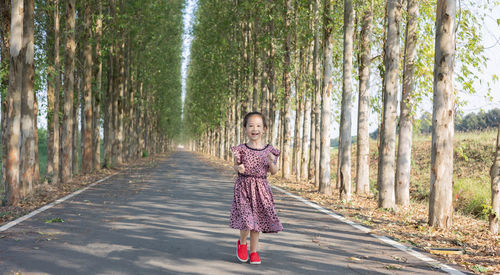 Full length rear view of girl walking in forest